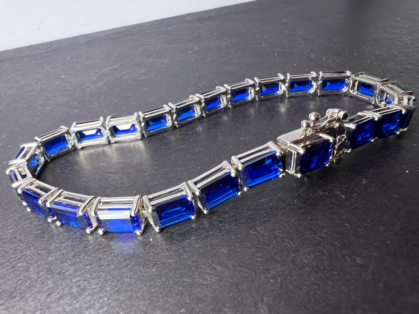 Lab created blue spinel emerald cut tennis bracelet in platinum over sterling silver 22.92 ctw